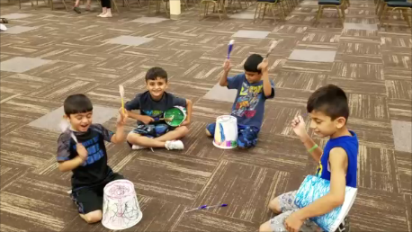 Our Summer Program kids drumming around in a circle